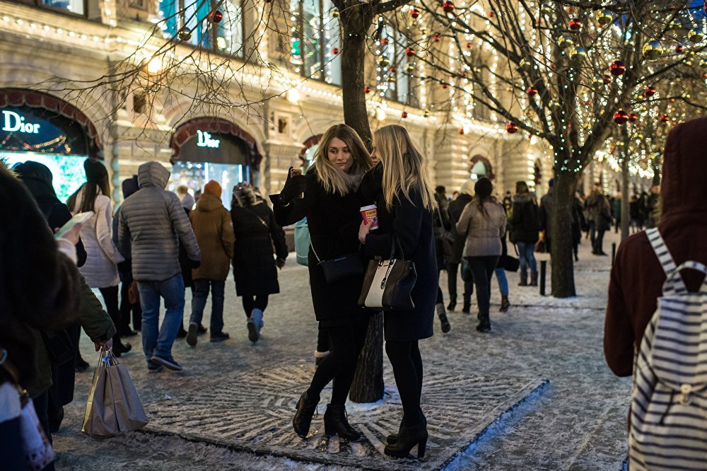 Hai cô gái chụp ảnh selfie giữa con phố đi bộ ở Moscow.