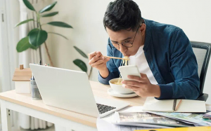 Vừa ăn vừa làm: Thói quen dễ thấy, tác hại khó lường